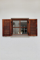 Window with wooden shutters, neutral colour wall. Traditional European old town building. Old historic architecture