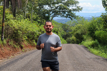 Young mid weight man jogging and smiling front view