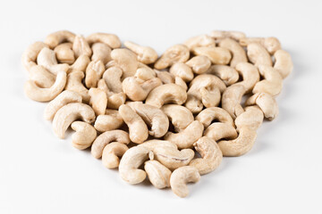 Figure of cashew nuts in the shape of a heart. Symbol of natural healthy food. Isolated figure on a white background - Powered by Adobe
