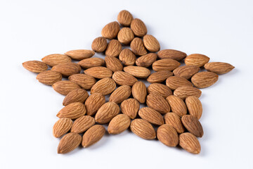 Figure of almond nuts in the shape of a heart. Symbol of natural healthy food. Isolated figure on a white background