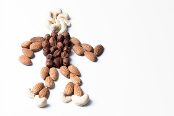 Figure of cashew and almond nuts in the shape of a man. Symbol of natural healthy food. Isolated figure on a white background