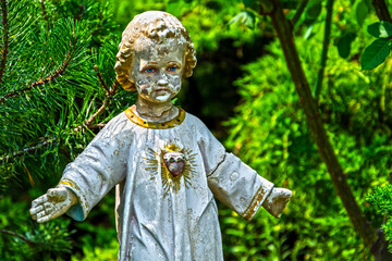 Old stone Jesus Christ in a green garden