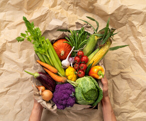 Healthy vegetables in basket. Photo of different vegetables on craft paper background, top view. High resolution product.