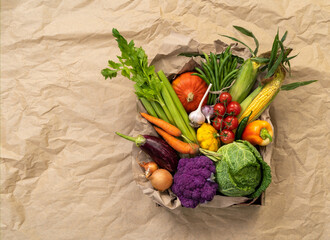 Healthy vegetables in basket. Photo of different vegetables on craft paper background, top view. High resolution product.