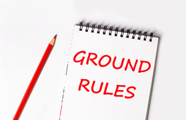 Red pencil and white notepad with the text GROUND RULES on a light background.