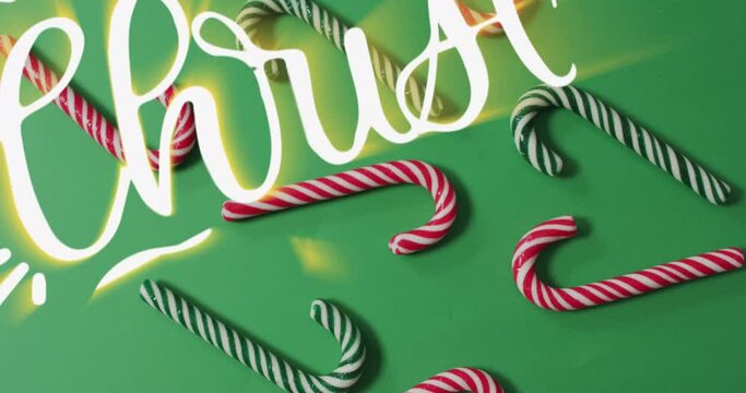 Animation of merry christmas text over candy canes