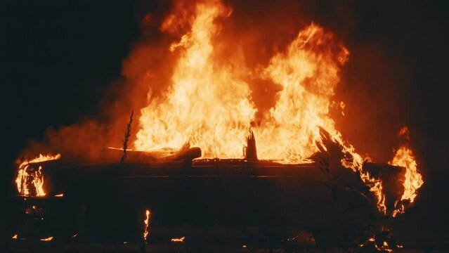 On street burning car in the city. Orange fired. Automobile engulfed in flames of fire. Explosion. Bomb. Car crash. Burning wheel. Emergency