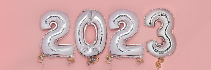 Balloon Bunting for celebration of New Year 2023 made from Silver Number Balloons. Holiday Party Decoration or postcard concept with top view and copy space. Banner size