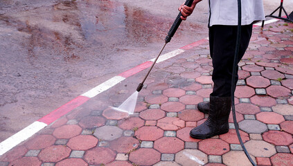 Workers cleaning roads and pavements with high-pressure cleaners, professional cleaners,...