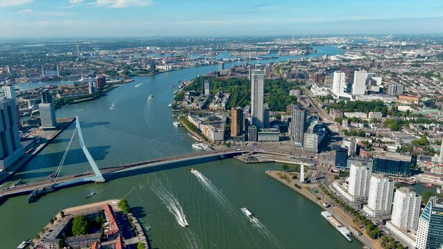 The city of Rotterdam aerial view and The Erasmusbrug (Erasmus Bridge) in Netherlands. Beautiful skyline drone shot ft. modern buildings also flying over Maas River, in Dutch province of South Holland