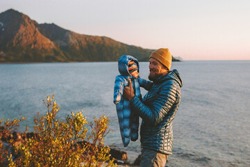 Father playing with baby outdoor family vacation lifestyle travel in Norway man with infant kid...
