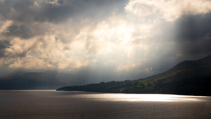 Photograph showing dramatic light rays through the clouds over Loch Tay in Scotland