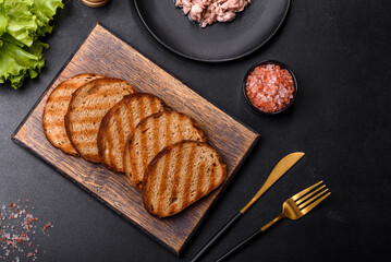 Delicious healthy sandwich with tuna, croutons, boiled egg, herbs and butter