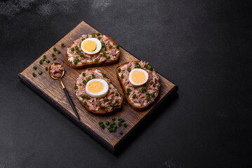 Delicious healthy sandwich with tuna, croutons, boiled egg, herbs and butter