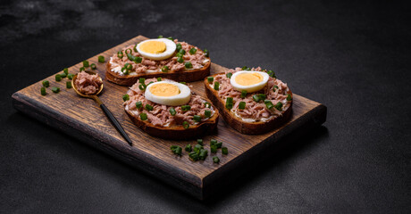 Delicious healthy sandwich with tuna, croutons, boiled egg, herbs and butter