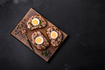 Delicious healthy sandwich with tuna, croutons, boiled egg, herbs and butter