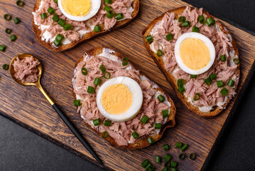 Delicious healthy sandwich with tuna, croutons, boiled egg, herbs and butter
