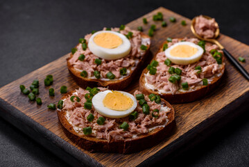 Delicious healthy sandwich with tuna, croutons, boiled egg, herbs and butter