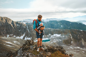 Man hiking with baby carrier travel family adventure vacation father with child in mountains...