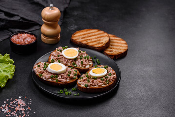 Delicious healthy sandwich with tuna, croutons, boiled egg, herbs and butter