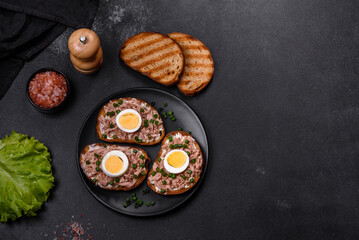 Fototapeta na wymiar Delicious healthy sandwich with tuna, croutons, boiled egg, herbs and butter