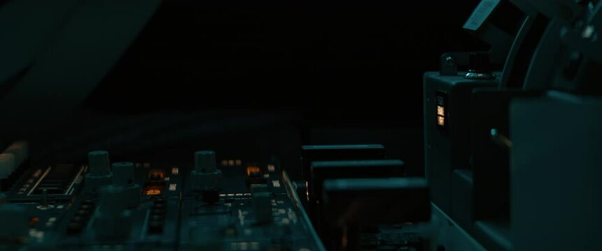 CU Commercial aircraft pilot adjusting flight parameters of the plane during the flight at high altitude. View from inside the cabin. Real aircraft, nighttime shot