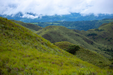 Naklejka premium cerro pelado - costa rican mountains covered with juicy grass - idyllic tropical landscape with blue sky and clouds