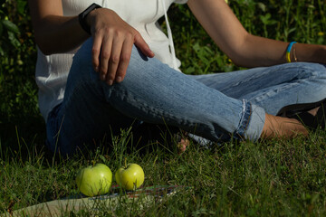 white apples lie on a book, woman sitting back