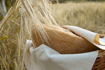 natural bread in ears of wheat, hot bread, wrapped in a linen napkin, natural colors, organic bread