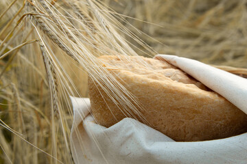 natural bread in ears of wheat, hot bread, wrapped in a linen napkin, natural colors, organic bread