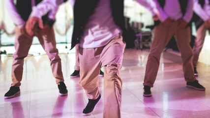 Group of hip-hop dancers performance on a stage, modern contemporary street dance with break dancing in studio, hip hop dance training  in a ballroom, legs in sneakers close up