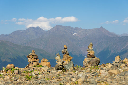 Pyramids of stones is built on a mountain pass. In the background Beautiful peaks of majestic mountains.