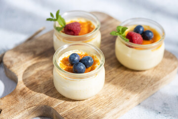 Dessert creme brulee garnished with a mint leaf and fresh blueberries and raspberries. Home recipes. Sweet snack