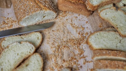 Slices of fresh bread and a cutting knife on a rustic table