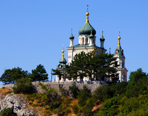 A beautiful church on a mountain on a sunny day against a clear blue sky.
