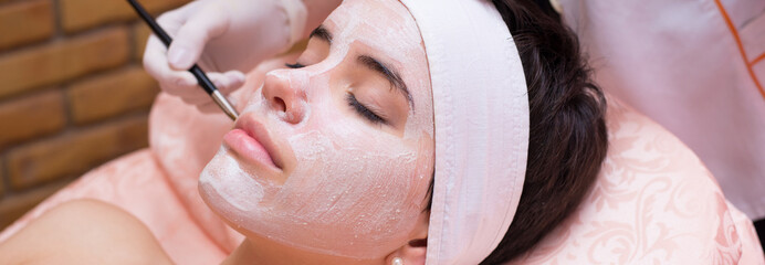 Girl with facial mask lying in beauty health spa center	