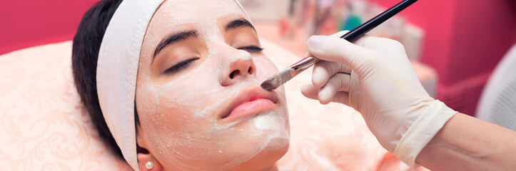 Girl with facial mask lying in beauty health spa center	