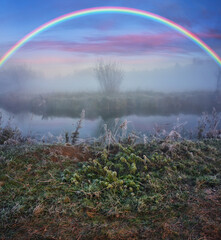 Amazing rainbow over the small rural river. autumn morning. nature of Ukraine