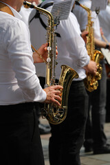Fototapeta premium sax player of the band during the musical event in the town square not recognizable