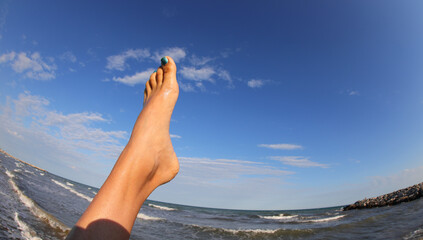 barefoot foot with sea background in summer photographed with fish eye lens