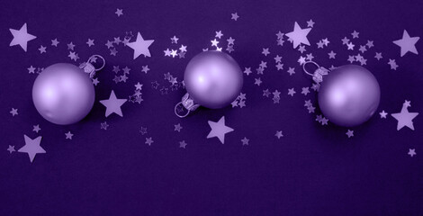 Obraz na płótnie Canvas Christmas balls with stars confetti toned in light purple background, color of the year 2022 very peri.