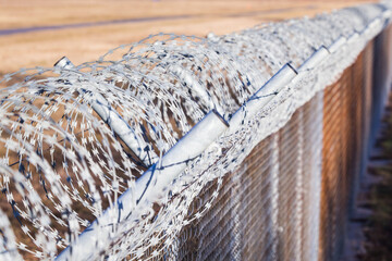 Barb wire rolls on a fence barrier at a border