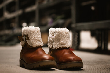 Old worn leather boots with sheepskin fur, fall winter insulated shoes for children. Retro...