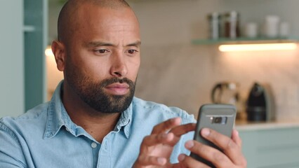 Unhappy, phone and man texting on a sofa, angry and annoyed with online pop up ads. Glitch, complain and frustrated black guy writing email or message to internet provider to cancel subscription
