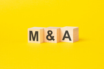 wooden blocks with text MA on yellow background. business concept