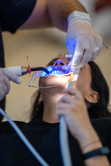 dentist at work applying blue light 