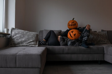 Pärchen mit Kürbissen auf dem Kopf auf der Couch an Halloween