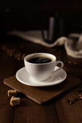 Cup of coffee and kettle beans at wood table