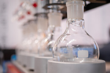 Laboratory equipment - empty glass flask on heating mantle in row. Chemistry, science,...