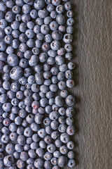 Fresh ripe whortleberries on black table. Copy space
